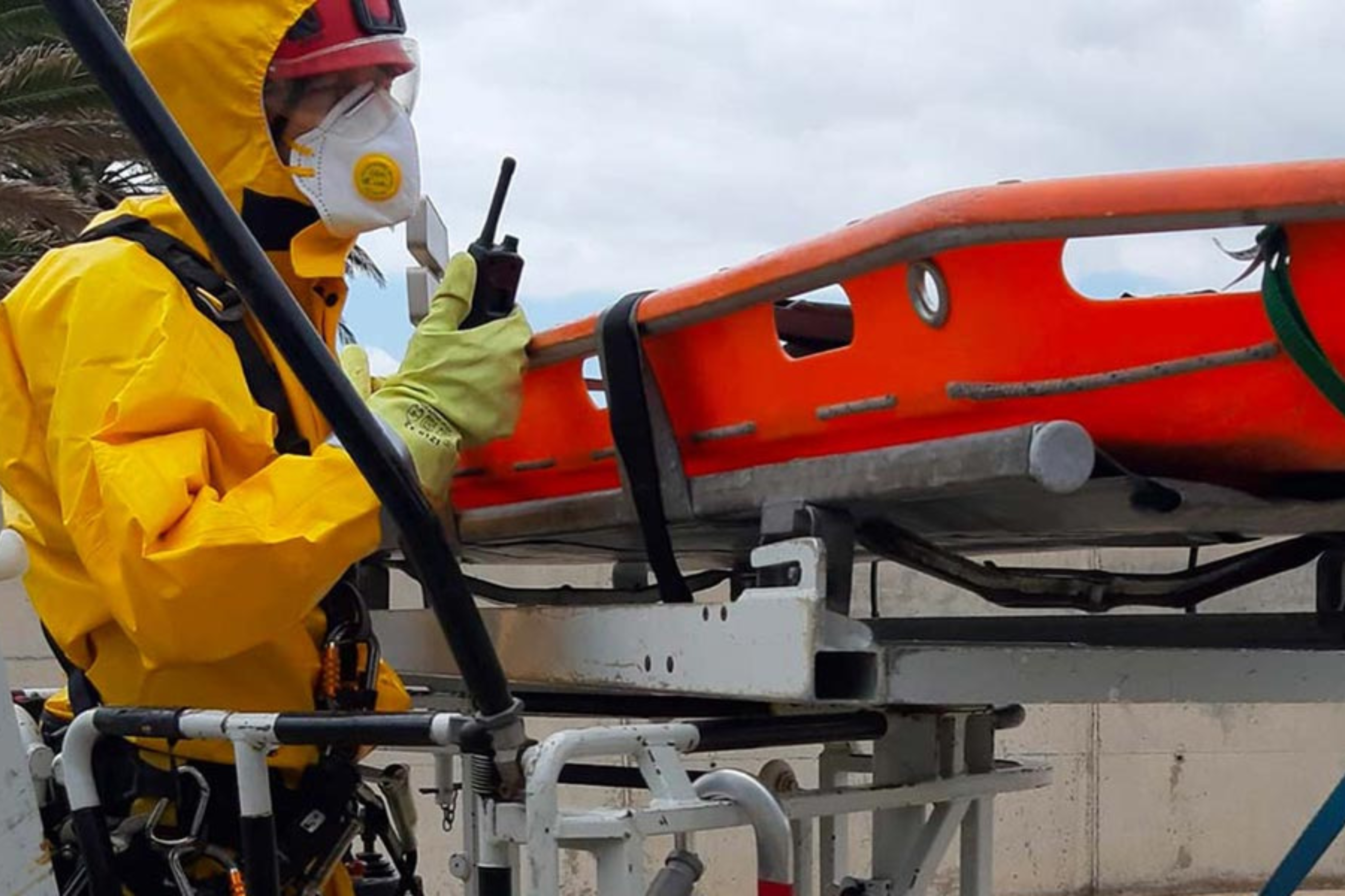 Persona con EPIs frente a una camilla de rescate.