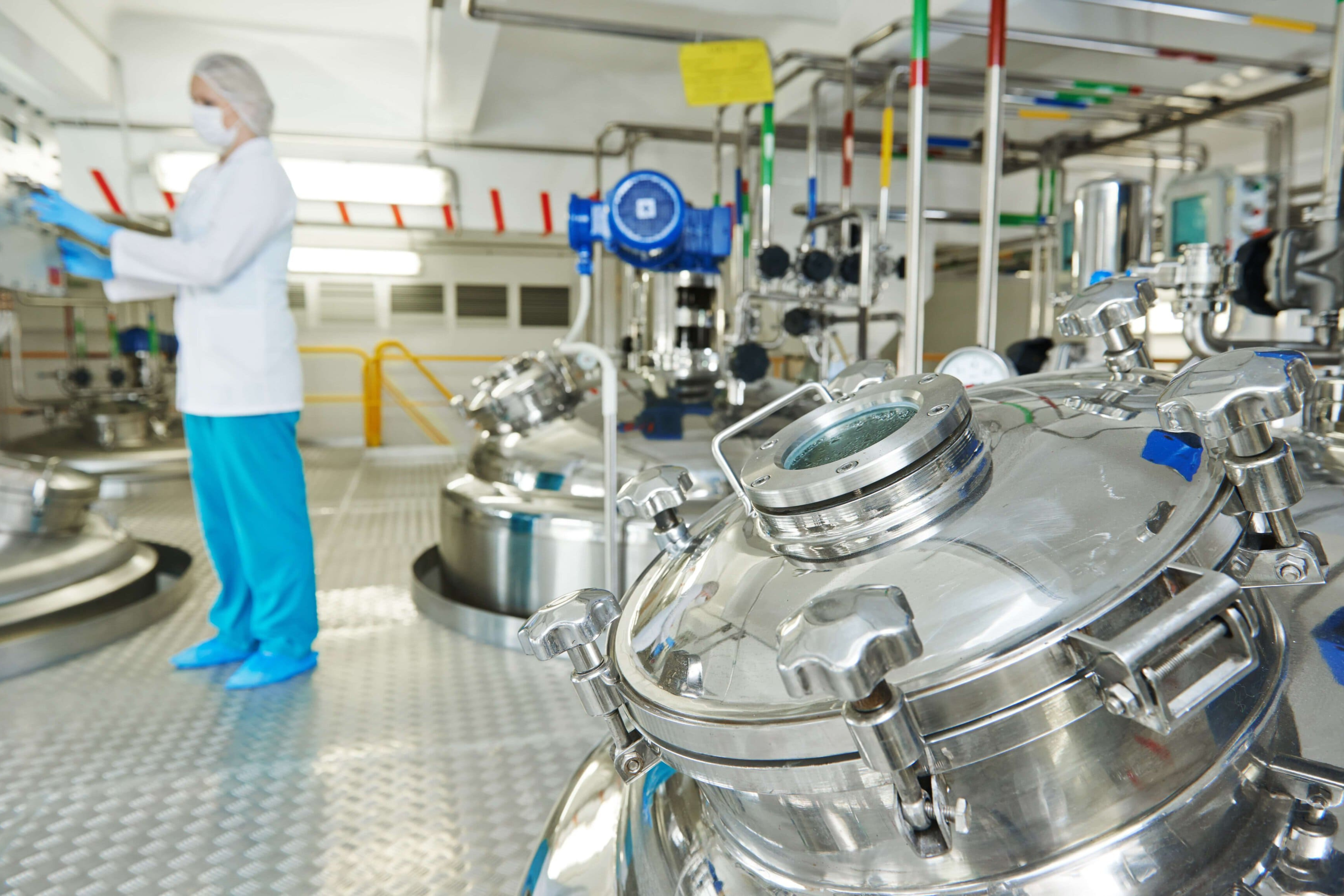 Una persona con traje de protección en una industria alimentaria.