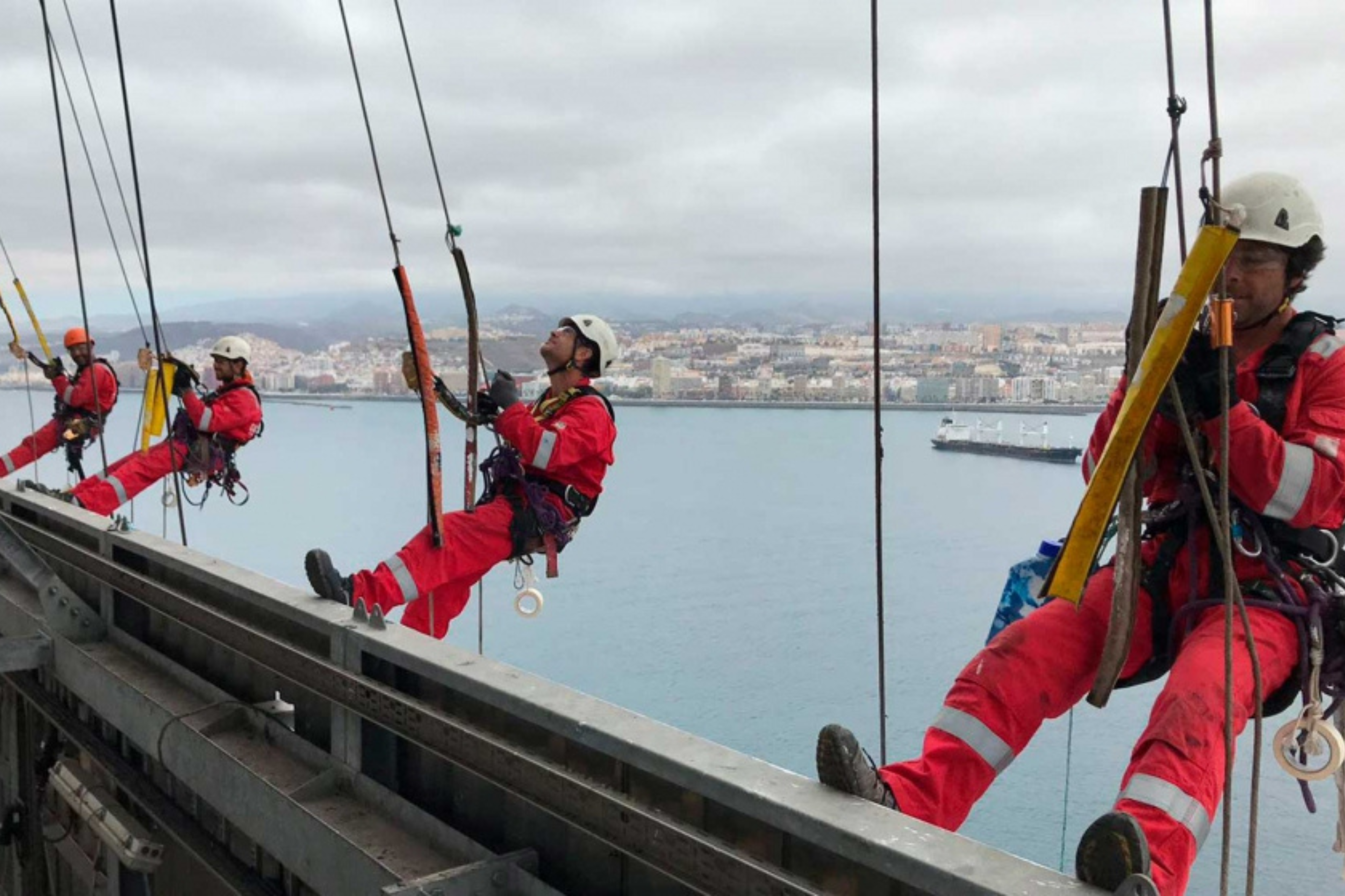 Cuatro trabajadores realizando trabajos en altura.