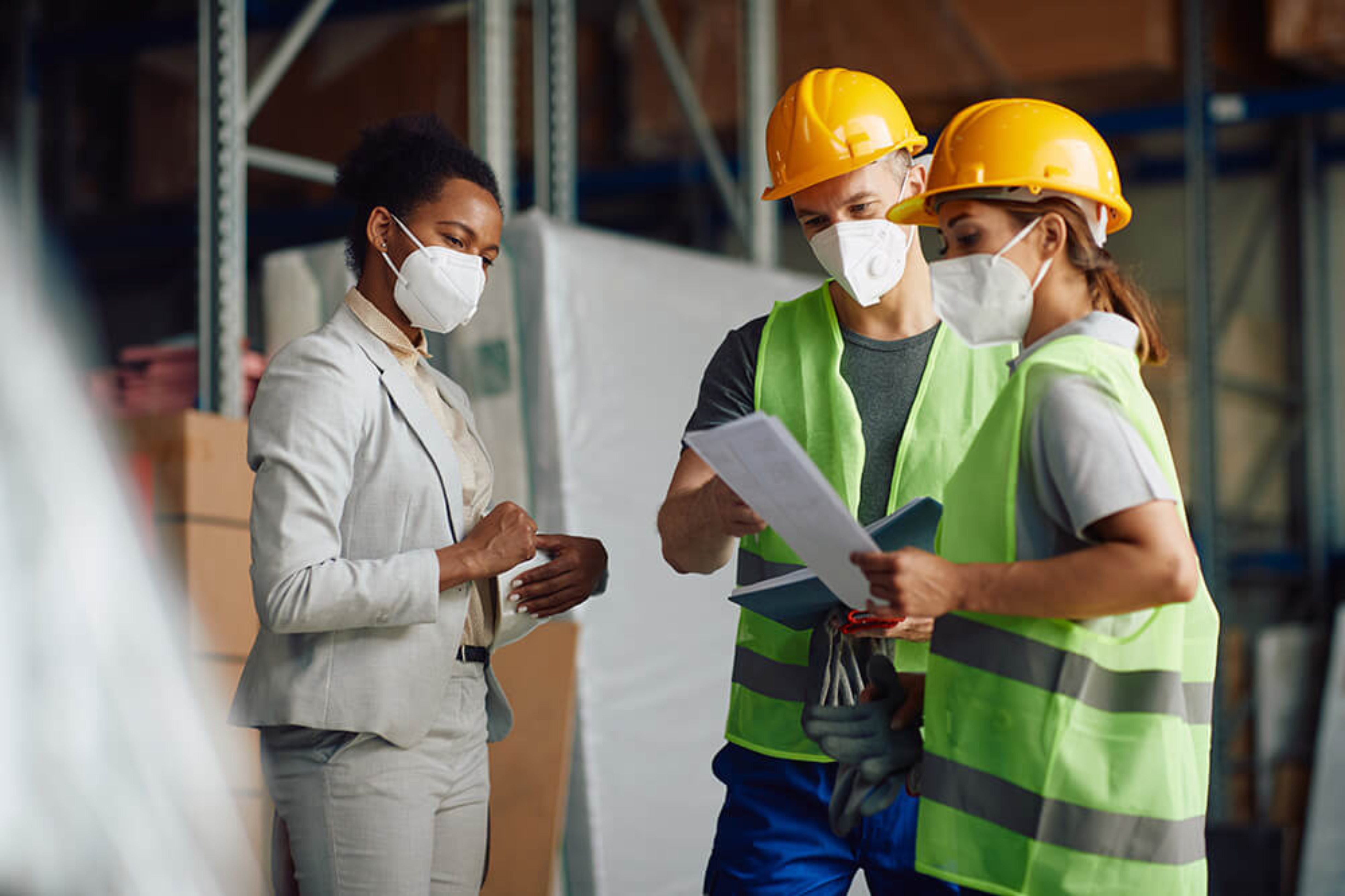Un grupo de personas con máscaras faciales y chalecos de seguridad.