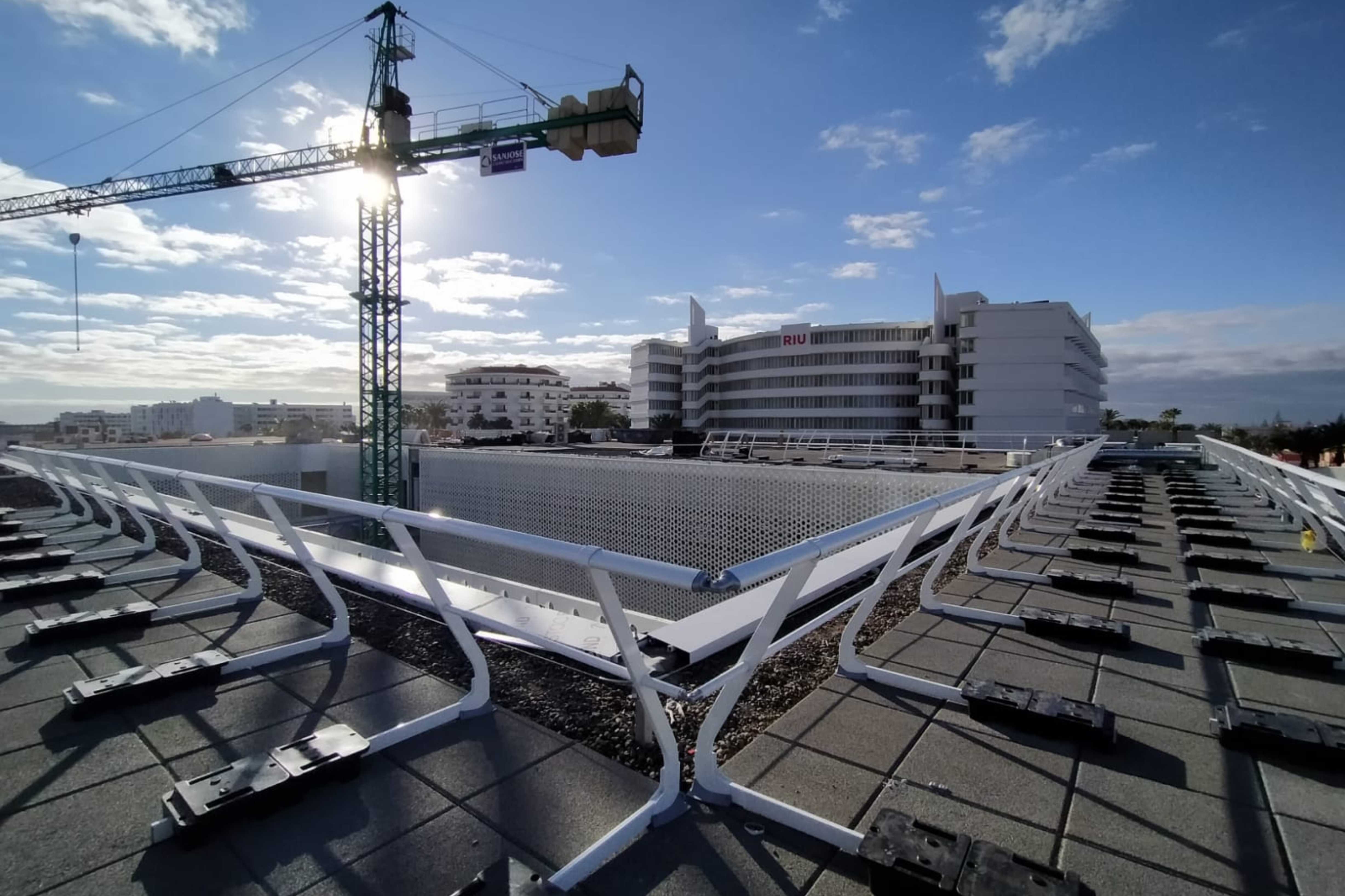 Imagen de unas barandillas en una cubierta, con una grúa en el fondo.