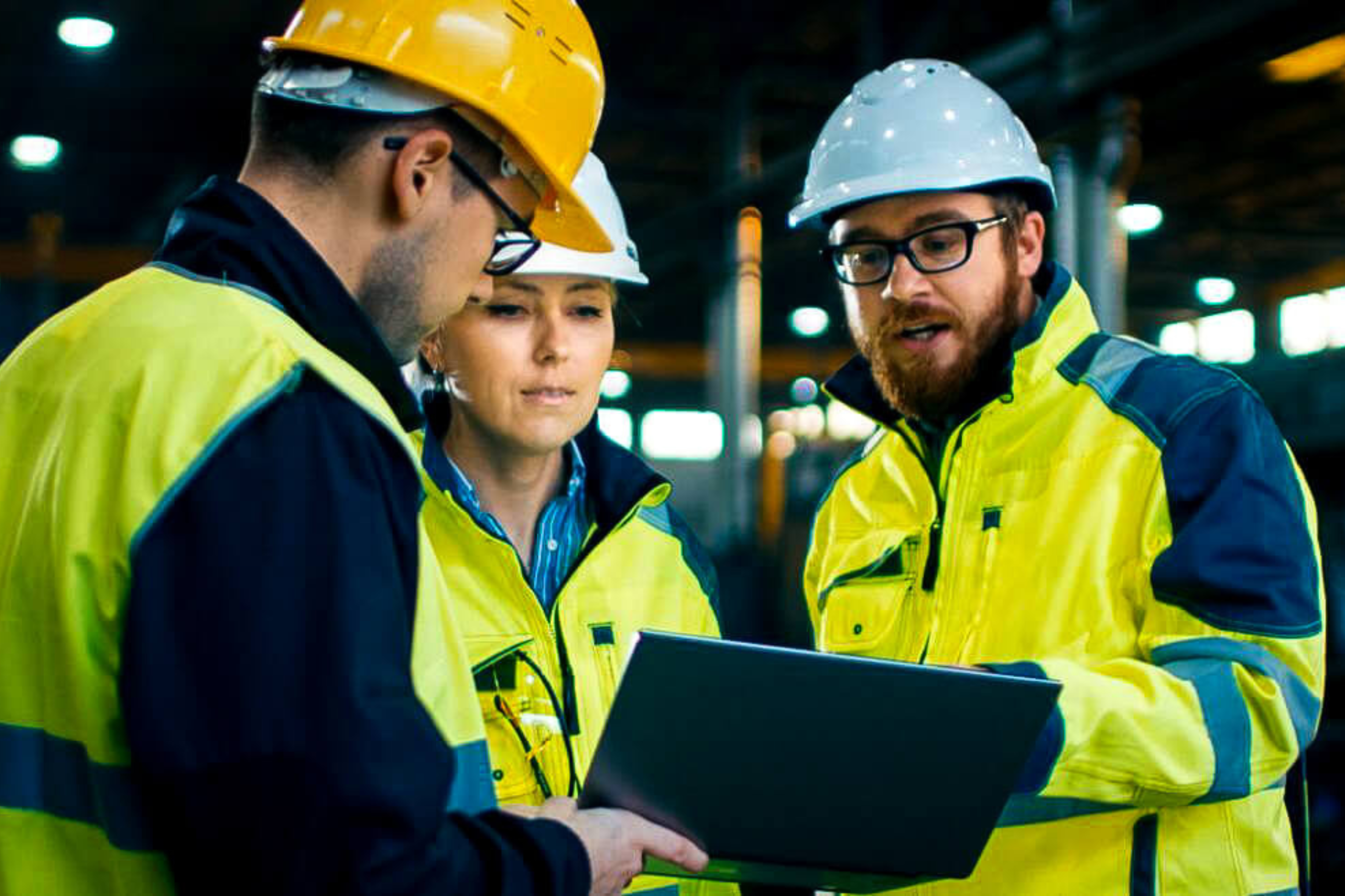 Tres personas con EPIs consultando una tablilla.