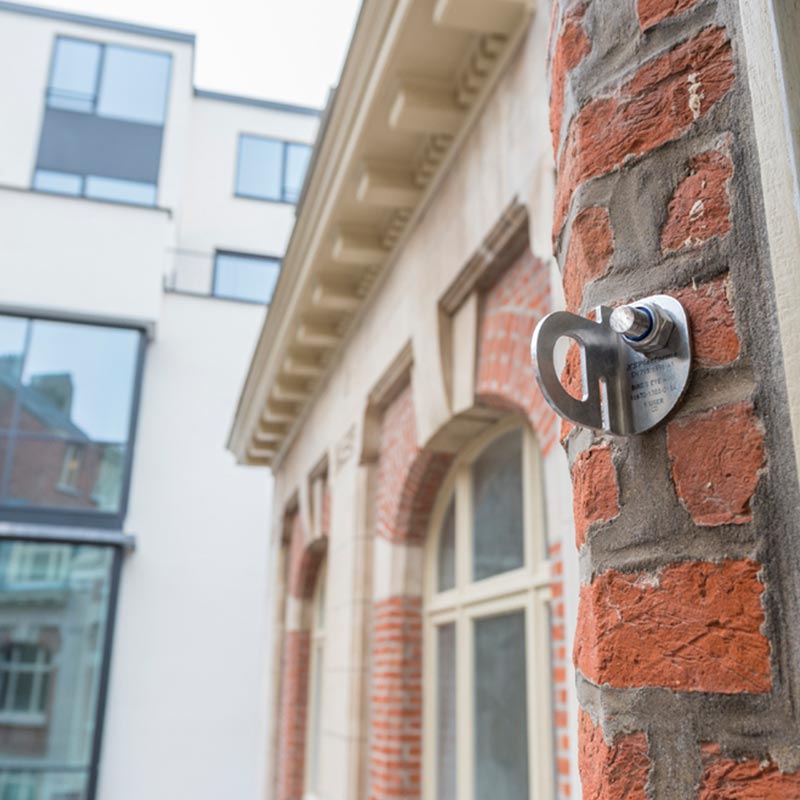 Imagen de un anclaje en el costado de un edificio de ladrillo.