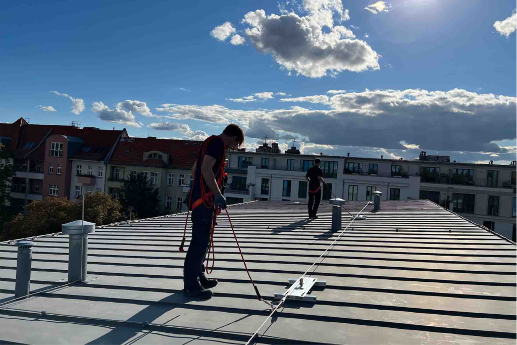 Dos operarios sobre una cubierta utilizando sistemas de retención.