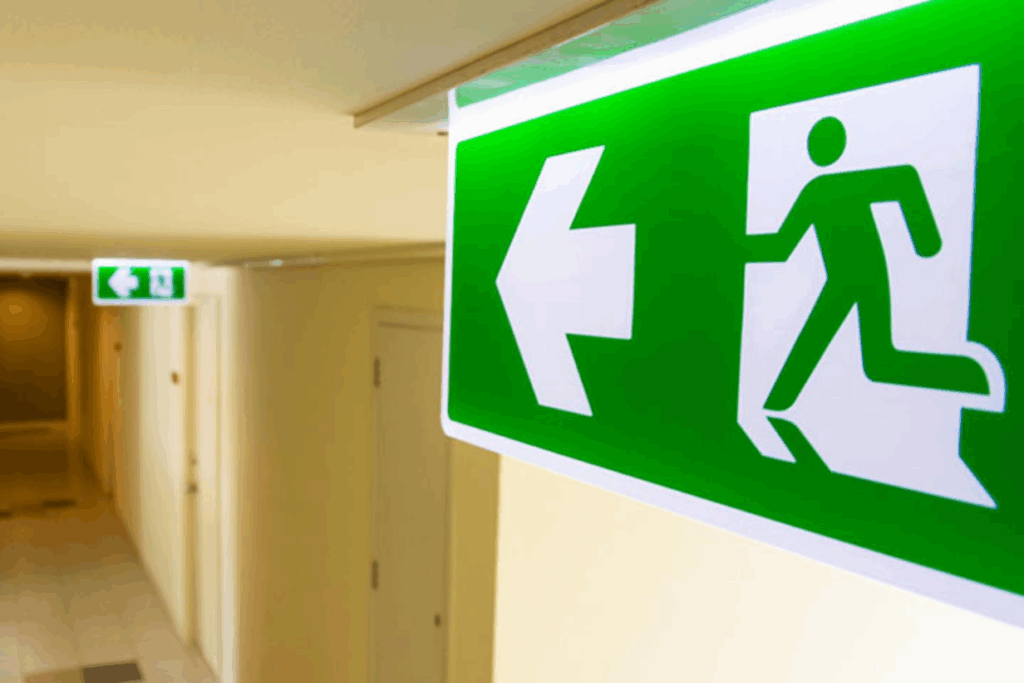 Imagen de unas señales de salida de emergencia o evacuación. Algo indispensable que debe recoger un plan de autoprotección.