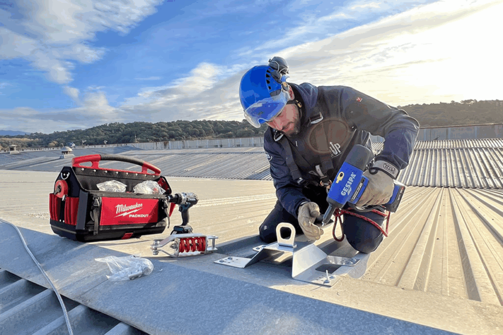 Imagen de un trabajador instalando una línea de vida certificada en una cubierta.